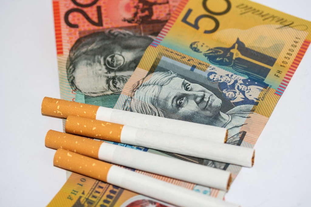 Expensive cigarettes and scattered ontop of piles of Australian money.